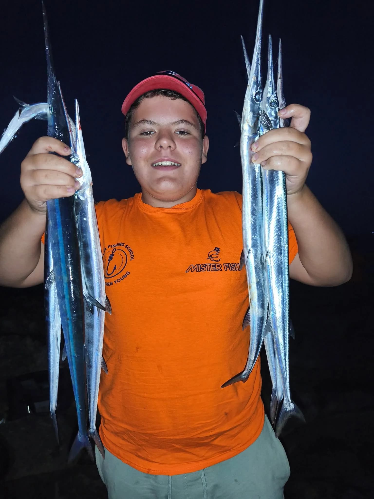 A young angler displaying two long fish during an evening session